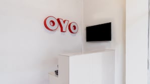 Una mesa de recepción con un televisor de pantalla plana montado encima.