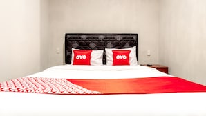 Una cama con una colcha rojo y blanco y dos almohadas con la palabra 