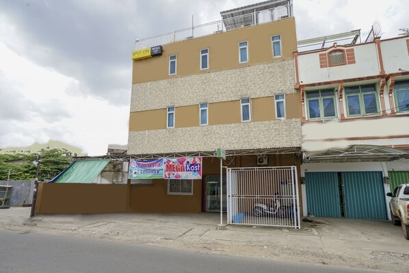 A multi-story building with a ground-level commercial space featuring a laundry service sign.