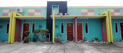 A building with a colorful facade, featuring a central black section and multiple doors.