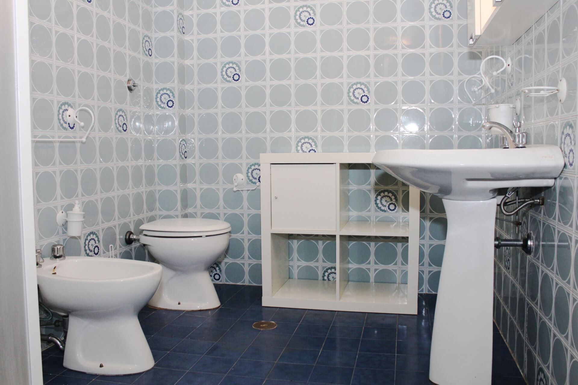 A bathroom with a toilet, bidet, and a sink.