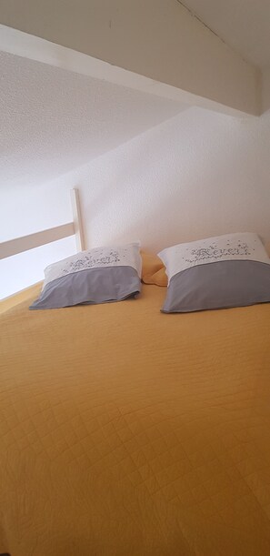 2 dormitorios y tabla de planchar con plancha