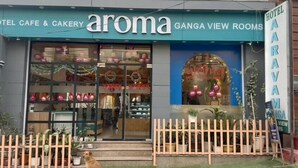 Un hôtel appelé « Aroma », avec une enseigne indiquant « Chambres avec vue sur le Gange ».