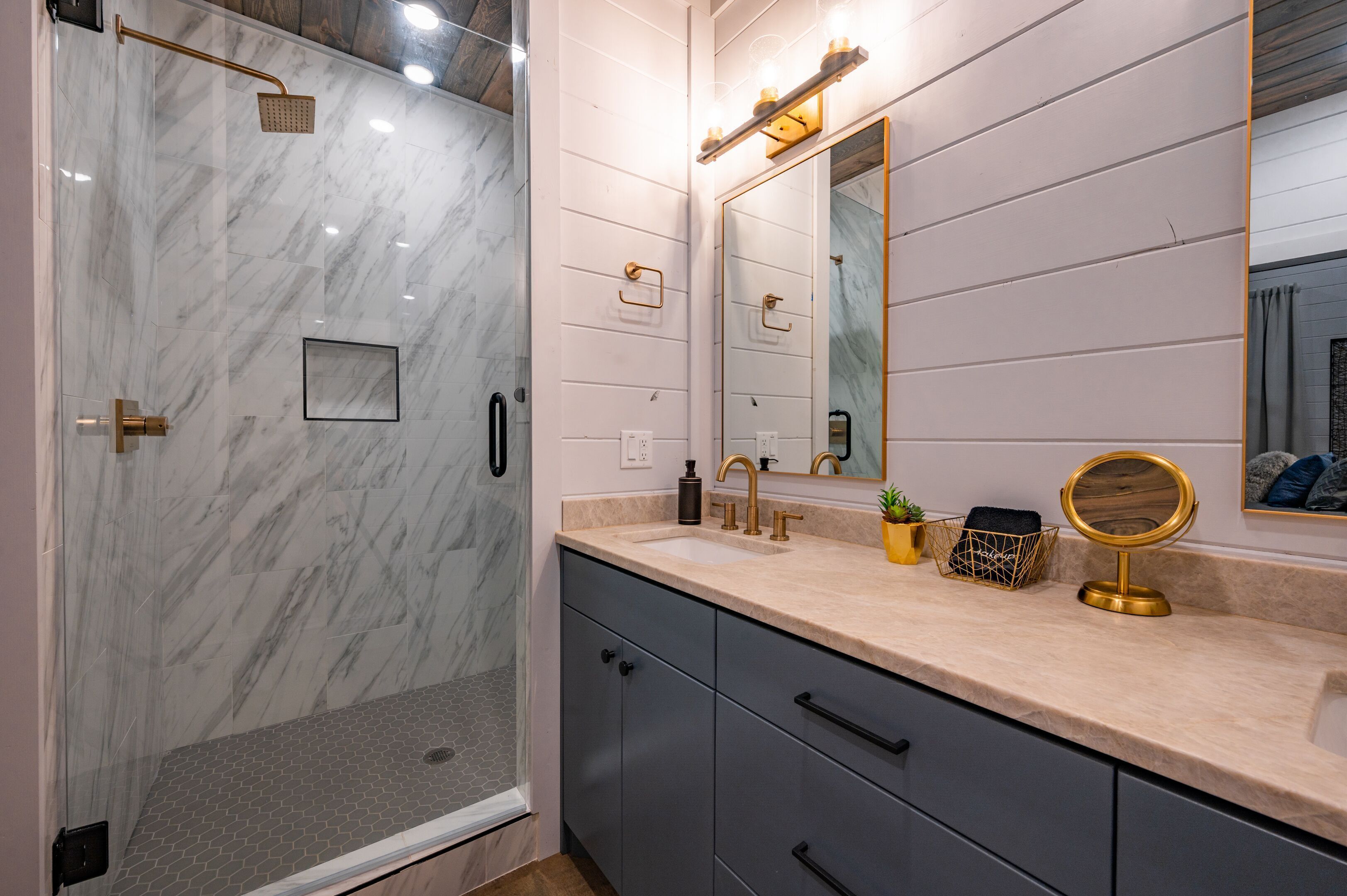 A modern bathroom with a shower, a sink, a mirror, and a vanity.