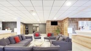 Eine moderne Lobby mit Sofas, einem Billardtisch und einer Rezeption.