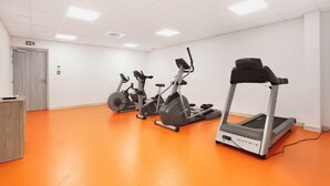 Ein Fitnessraum mit drei Ergometer und einem Laufband.