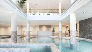 Ein Innenpool mit mehreren Ebenen, gefliesten Wänden und einer zentralen Wasserspülung.