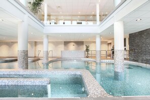 Ein Innenpool mit mehreren Ebenen, gefliesten Wänden und einer zentralen Wasserspülung.
