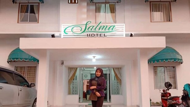 A hotel entrance with a sign reading "Salma Hotel," a car parked to the left, and a motorcycle to the right. - Hotel Salma (Bukittinggi)