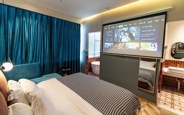A hotel room with a bed, a TV screen displaying content, a bathroom with a bathtub, and a mirror. - LIA HOTEL (Shenzhen)