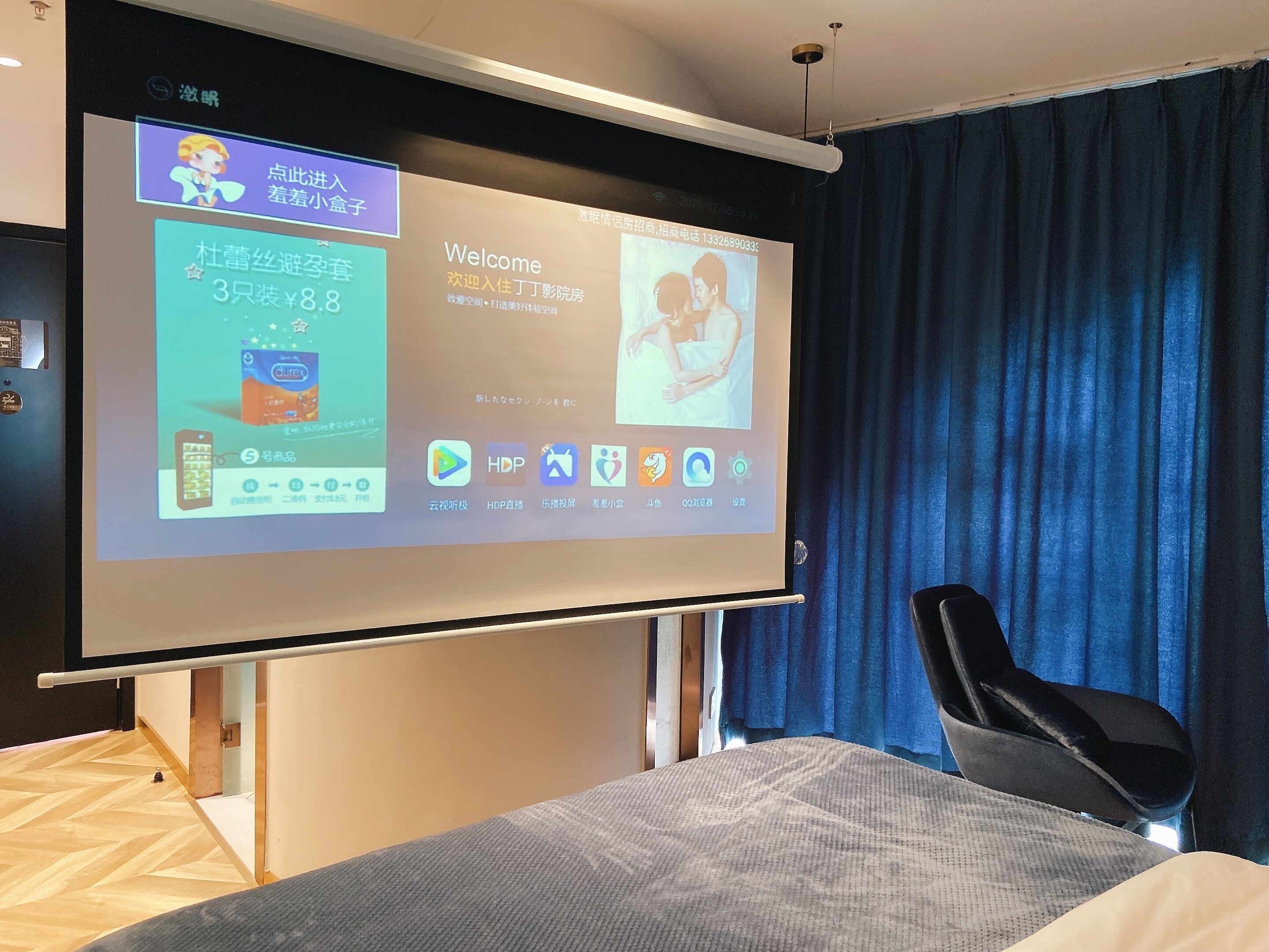 A hotel room with a large screen displaying a welcome message and room amenities.