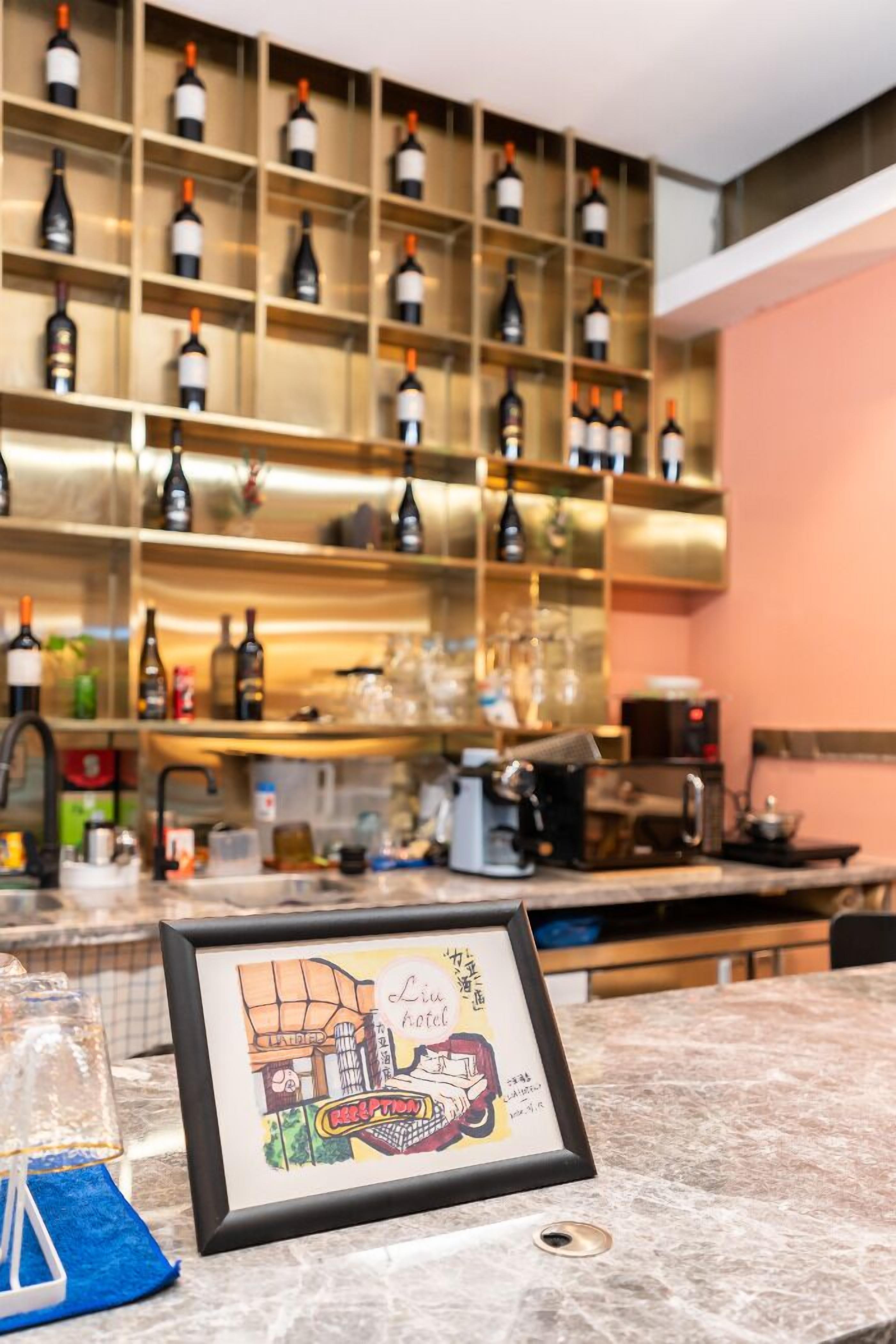 A bar area with shelves of wine bottles, a coffee machine, and a framed picture on the counter.