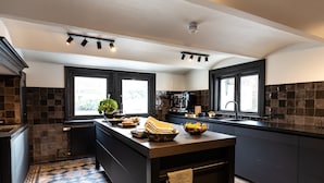 Una cucina moderna con mobili scuri, un'isola centrale e un pavimento decorato.