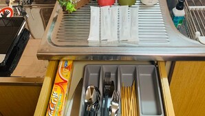 A kitchen counter with various utensils, a plant, and a 'Sweet Home' sign. - Hotel-Ikoi-Komagome 202 (Tokyo)