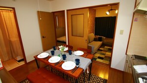 A compact living space with a dining area, a sofa, and a kitchenette. - Hotel-Ikoi-Komagome 202 (Tokyo)