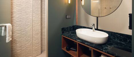 A bathroom with a marble sink, a large mirror, and a towel rack.