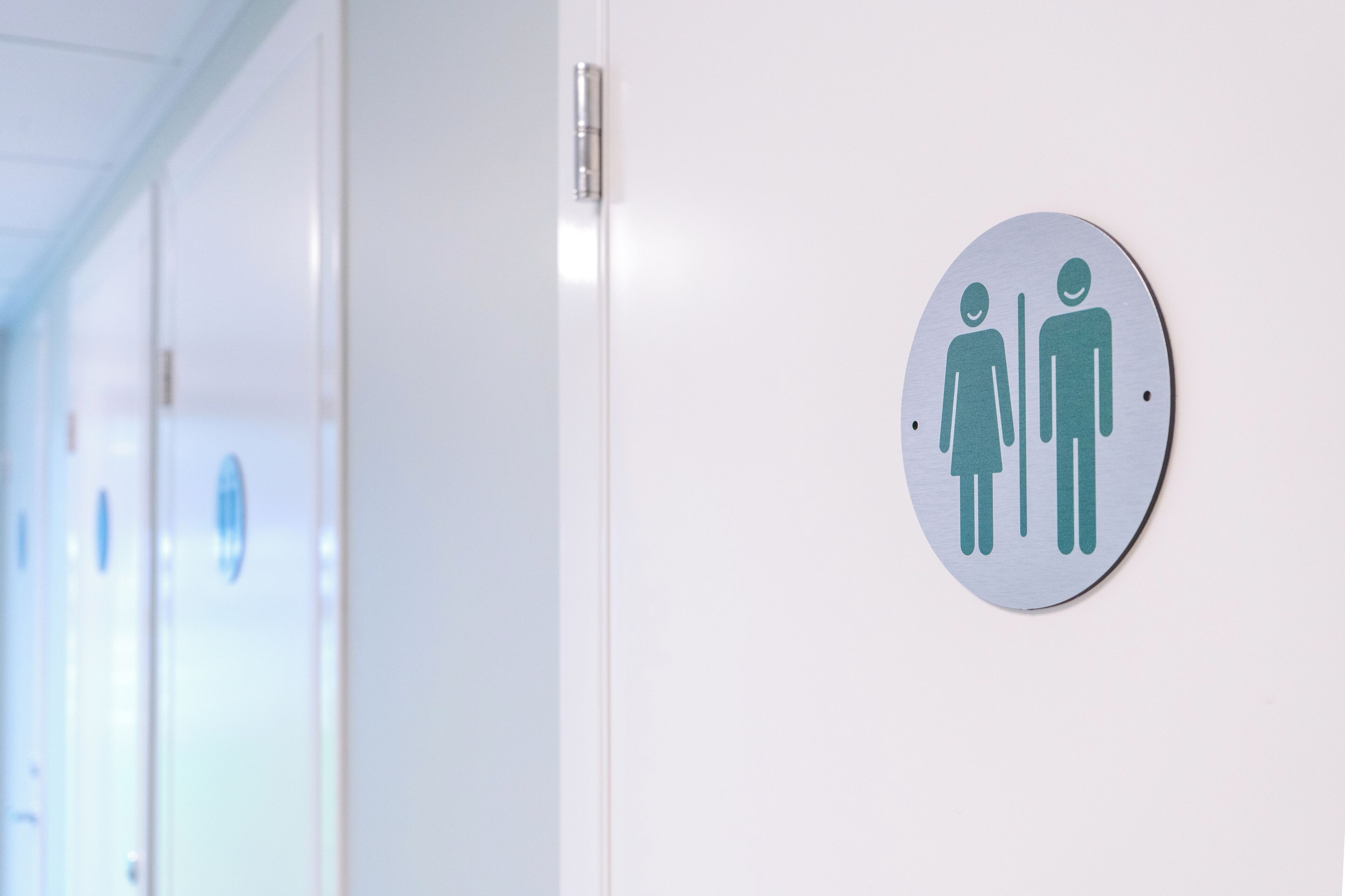 A restroom with a gender-neutral sign on the wall.