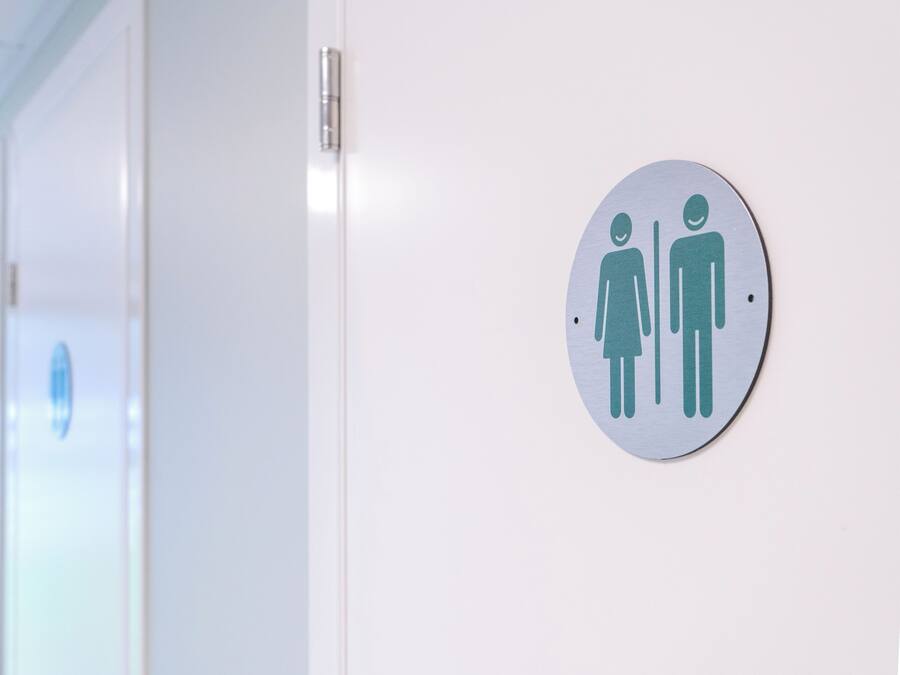 A restroom with a gender-neutral sign on the wall.