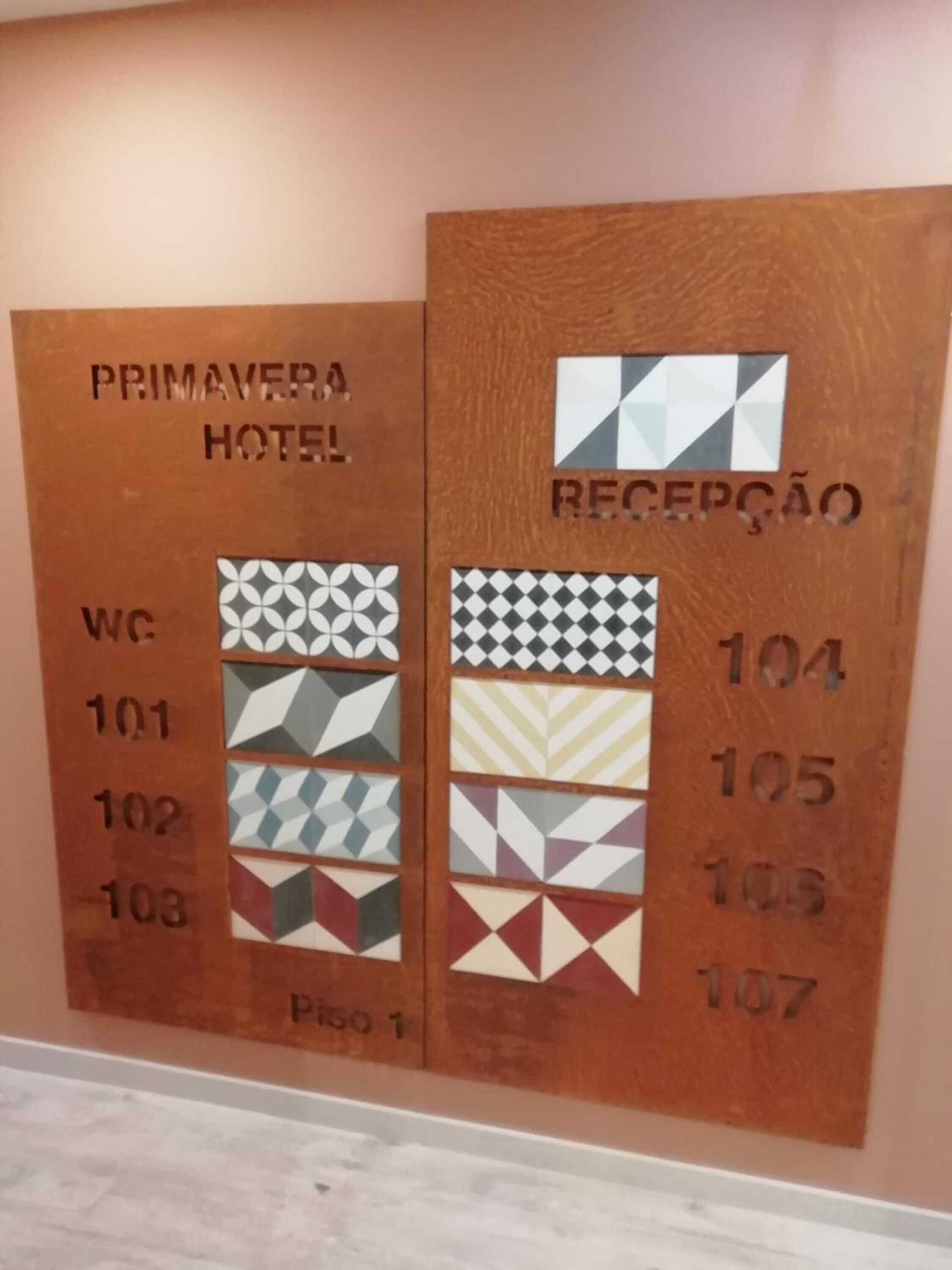Een receptiewand in een hotel met kamer nummers en bijbehorende plattegronden.