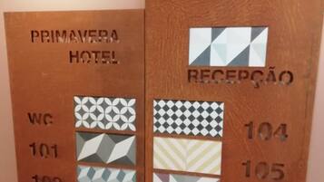 Een receptiewand in een hotel met kamer nummers en bijbehorende plattegronden.