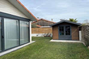 A modern house with a large sliding glass door, a small attached garage, and a well-maintained lawn. - VILLA Biscarosse Ville - 6 pers. - 3 rooms (Biscarrosse)