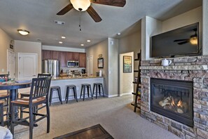 Cozy living space with a central fireplace, flat-screen TV, and dining area.