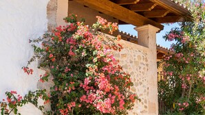 Un edificio de piedra con balcón de madera, una maceta y una jardinera.
