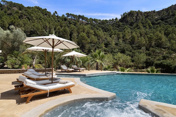 Una piscina techada, una piscina al aire libre, sombrillas