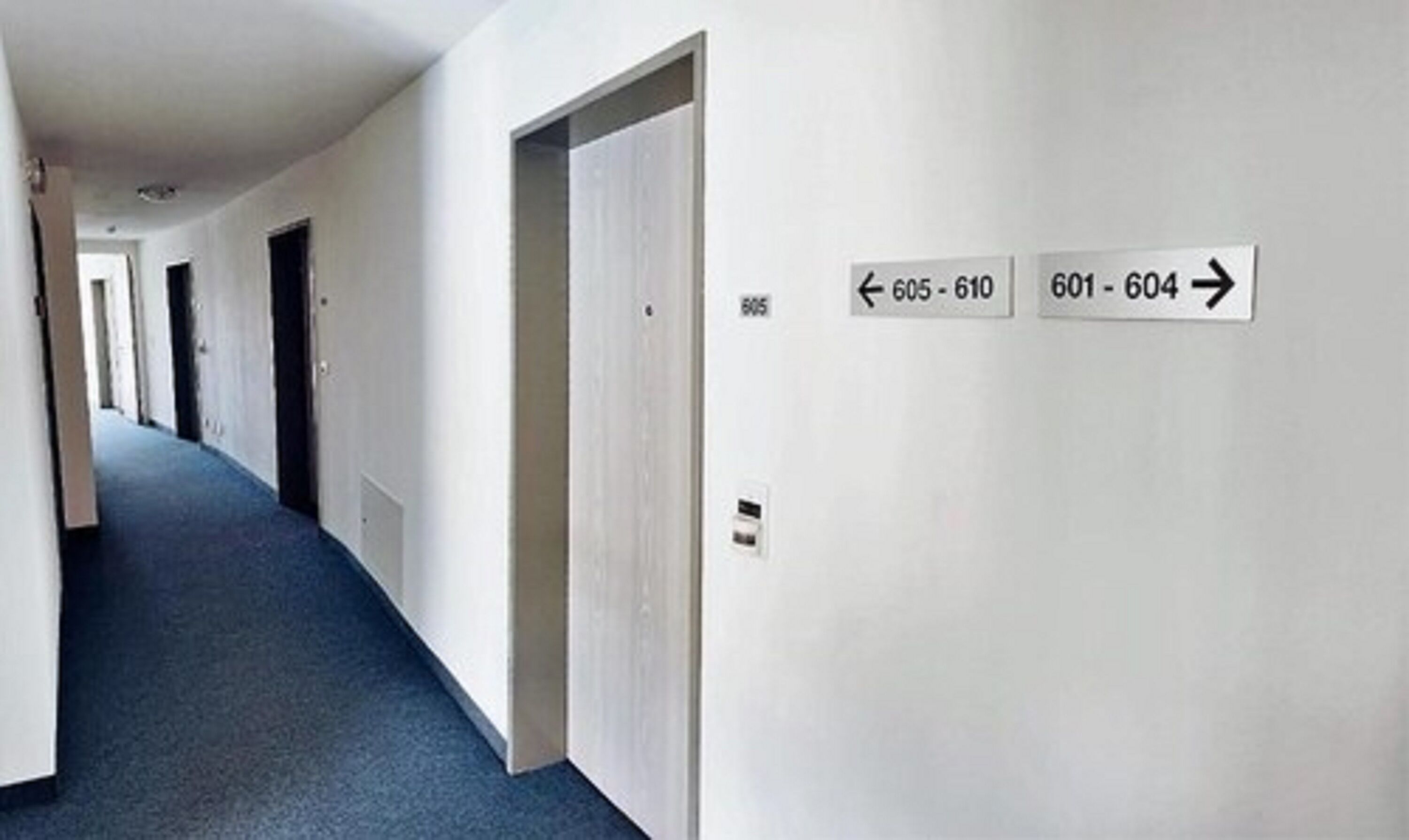 A hallway with doors numbered 605-610 and 601-604, indicating a hotel or apartment building.
