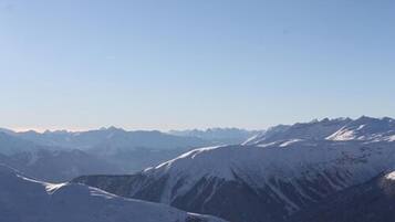 A mountain landscape with snow-covered peaks and a clear sky.