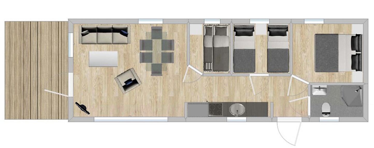 A hotel room layout with a kitchenette, a seating area with a sofa and chairs, a bed, and a small bathroom.