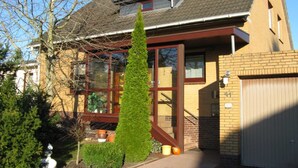Et toetagers hus med et stort vindue, skorsten og garage.