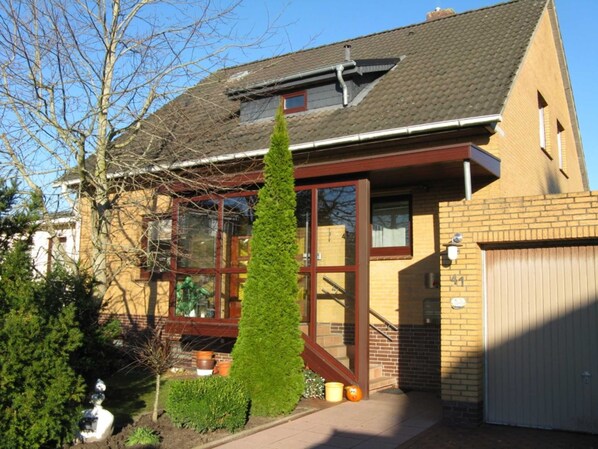 A two-story house with a large window, a chimney, and a garage.