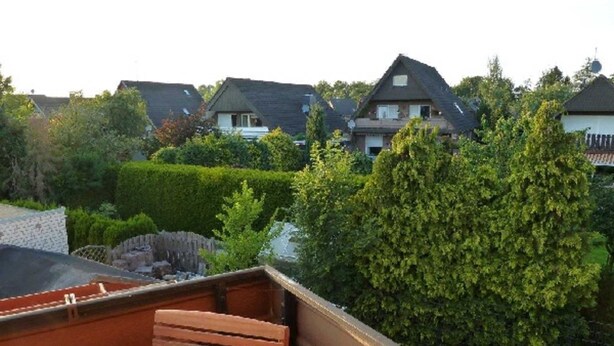 Et boligområde med huse, en træbænk og en velplejet have.