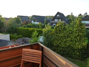 A residential area with houses, a wooden bench, and a well-maintained garden.