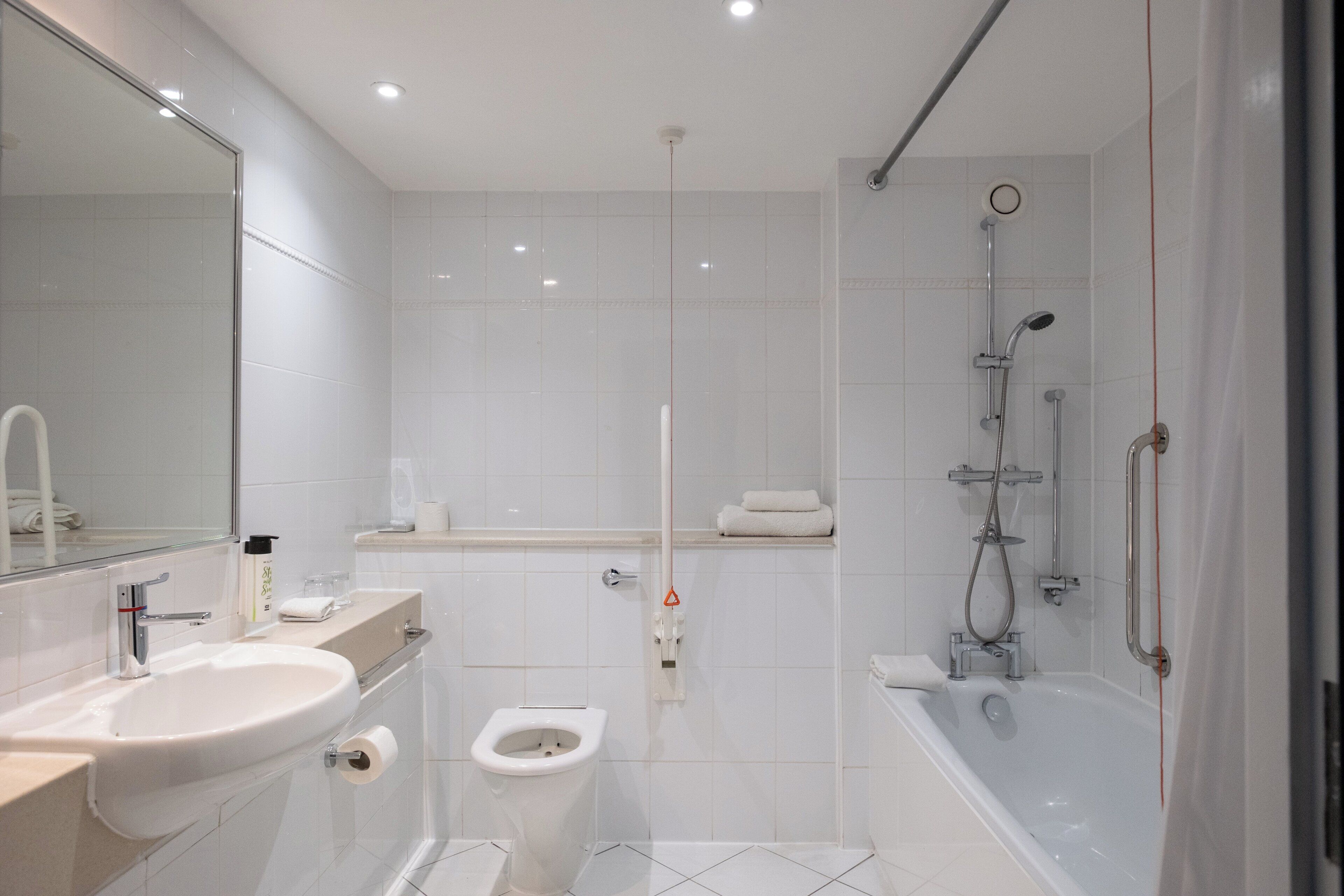 A modern bathroom with a sink, toilet, and shower.