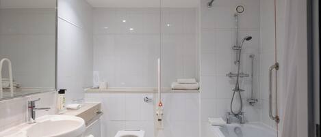 Un baño moderno con lavamanos, inodoro y ducha.