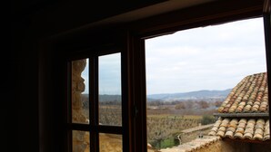 Ein Gebäude aus Stein mit einem Ziegeldach und Blick auf ein Tal.