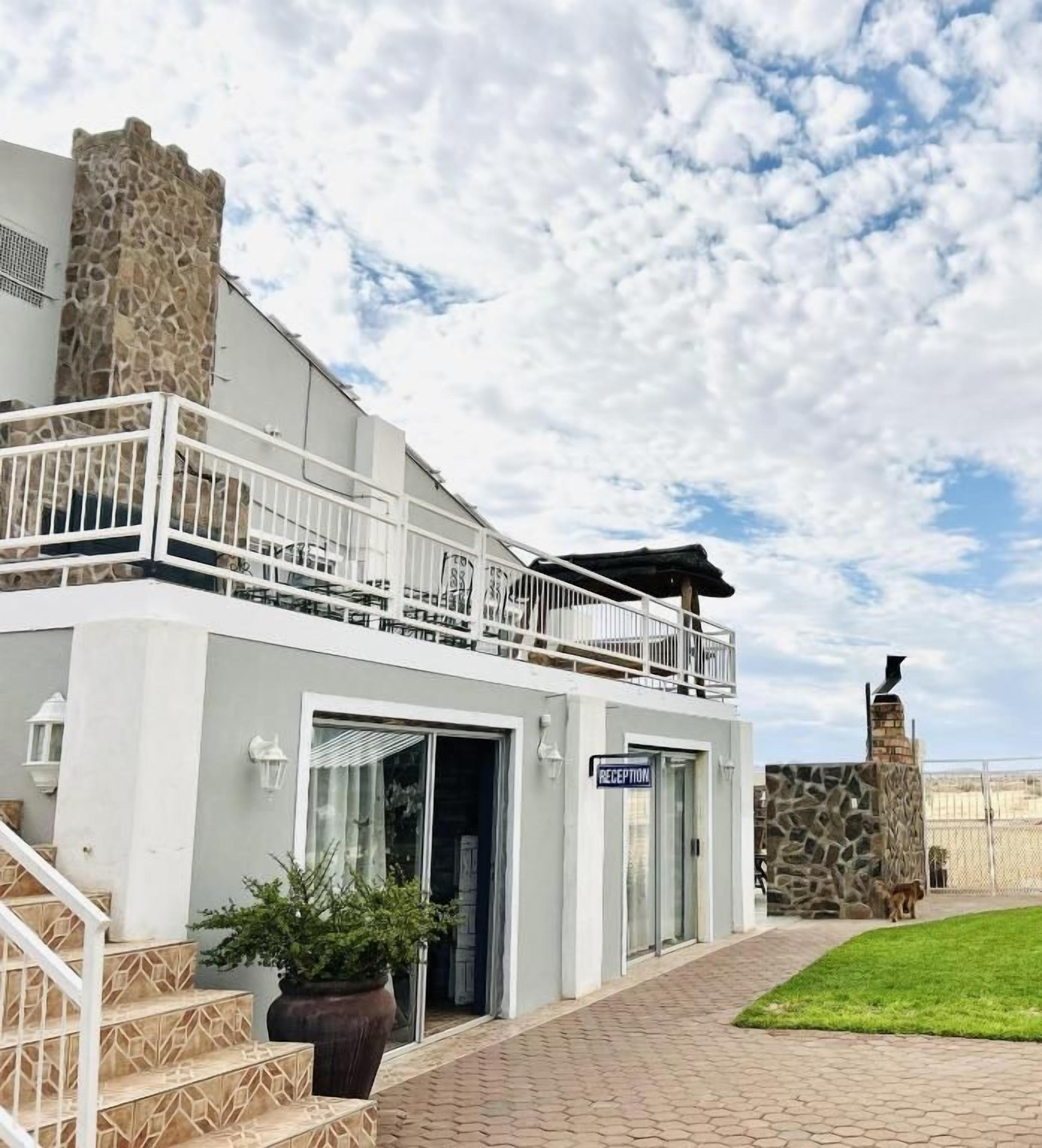 Un edificio moderno con una recepción, una torre de piedra y un balcón.