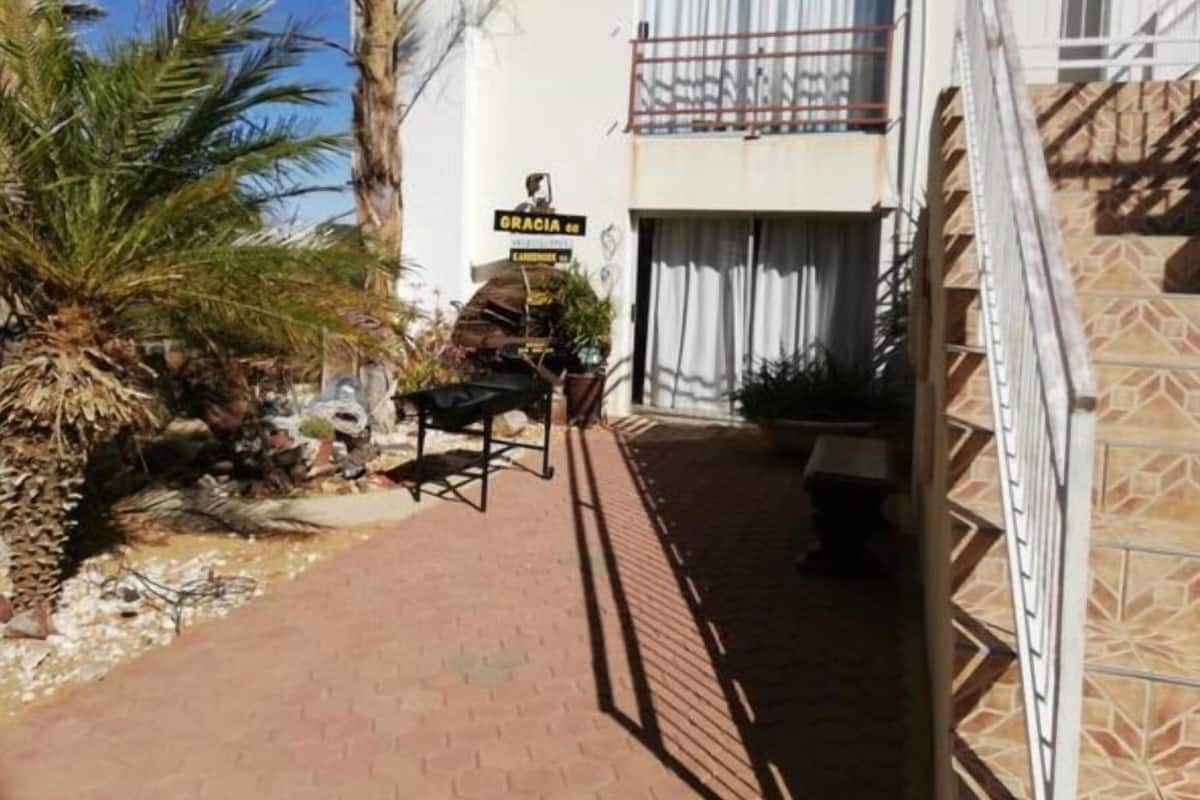 Un sendero estrecho que conduce a un edificio con un letrero que dice 'GRACIA de'.