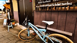 A bicycle parked in front of a building with a sign that reads "Nikko Guesthouse - Sumica - We are a Japanese style hostel for budget travelers." - Nikko Guesthouse Sumica - Hostel (Nikko)