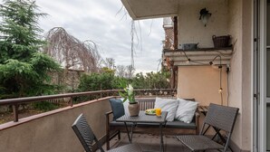 A balcony with a table, chairs, and a potted plant. - P&O Apartments Okecie 5 (Warsaw)