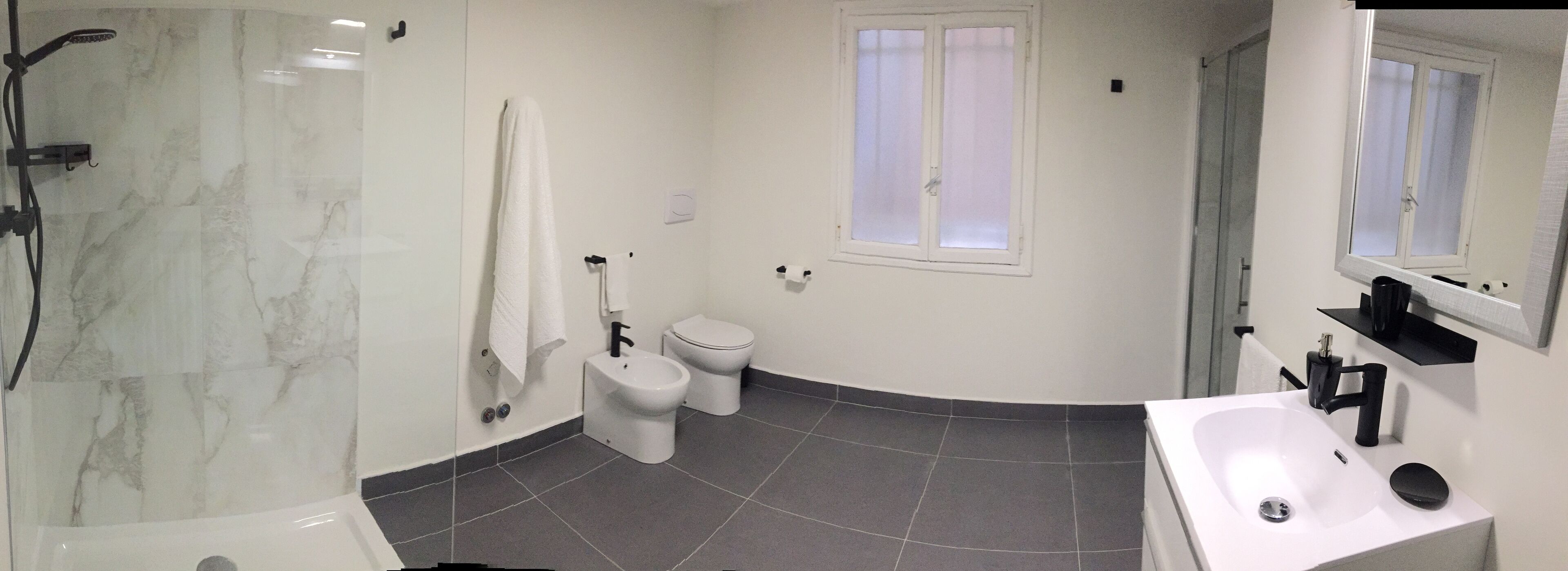 Ein Badezimmer mit Dusche, Toilette und Waschbecken.