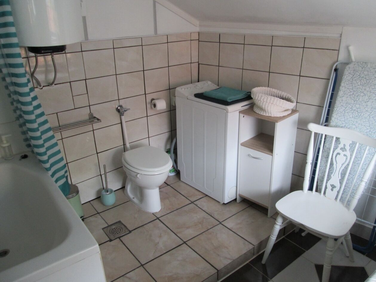 A small, clean bathroom with a toilet, sink, and a shower area.