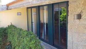 Ein Gebäude mit gelber Außenwand, einem Schild mit der Aufschrift "Casa da Galinha" und einer Glastür mit Metallgitter.