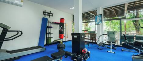 Un gimnasio con cintas de correr, bancos de pesas y un saco de boxeo.