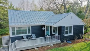 Ein zweistöckiges Haus mit einer Veranda und einem kleinen Deck.