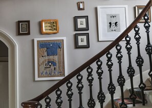 A staircase with ornate black balusters and a wooden handrail. - Washington House (Nairn)