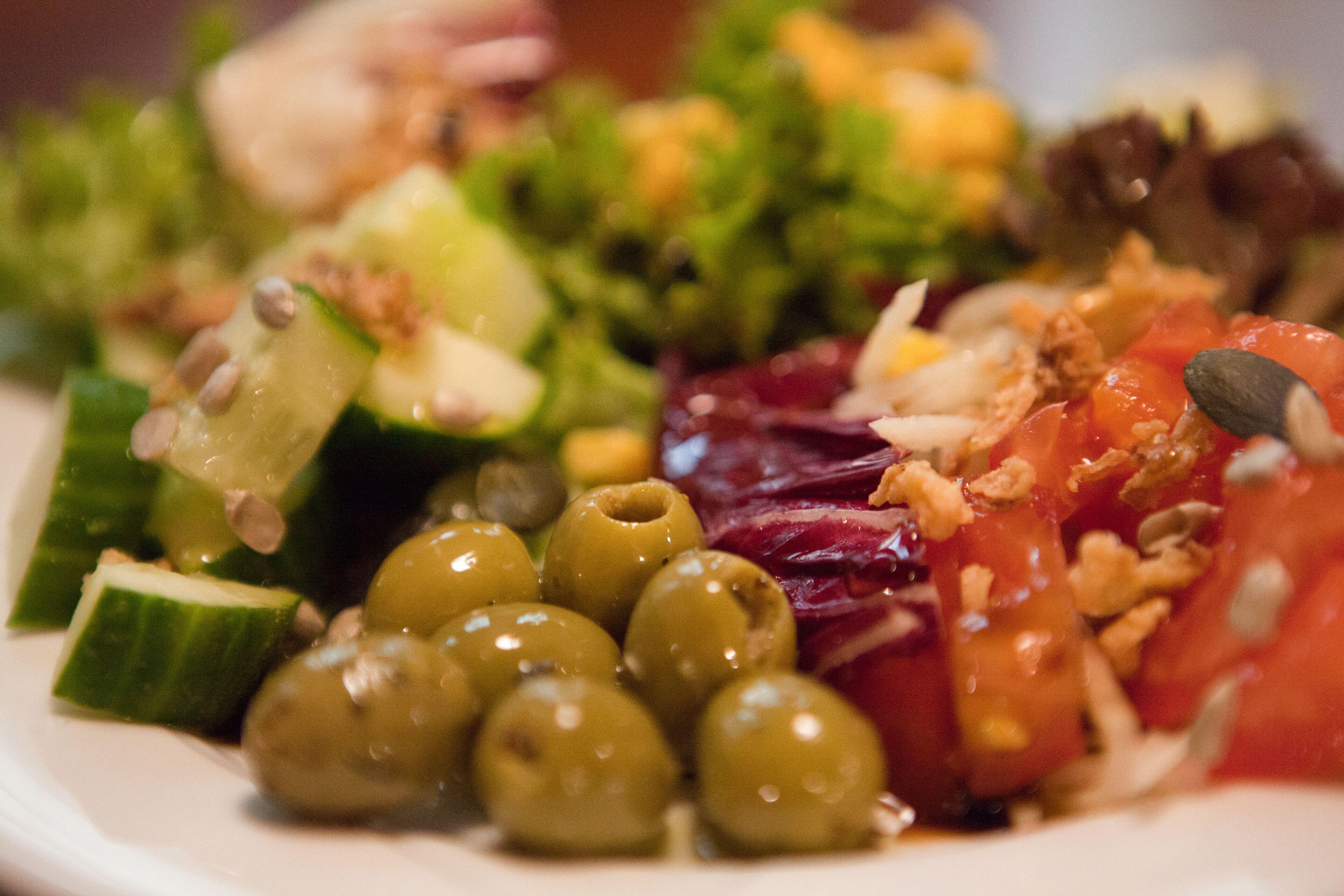 A plate of mixed salad with various vegetables and nuts.