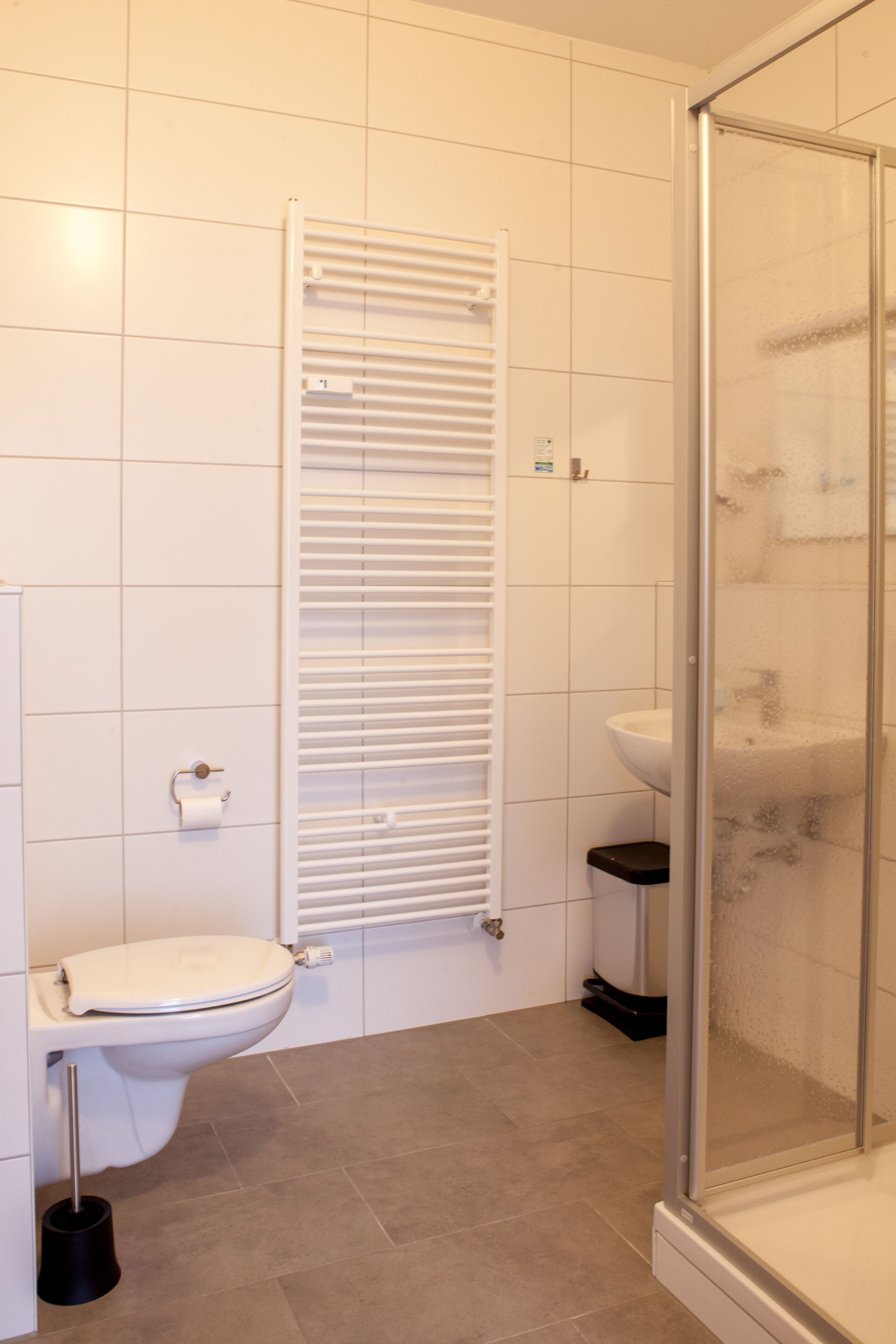 Ein Badezimmer mit Toilette, Waschbecken und Duschkabine aus Glas.